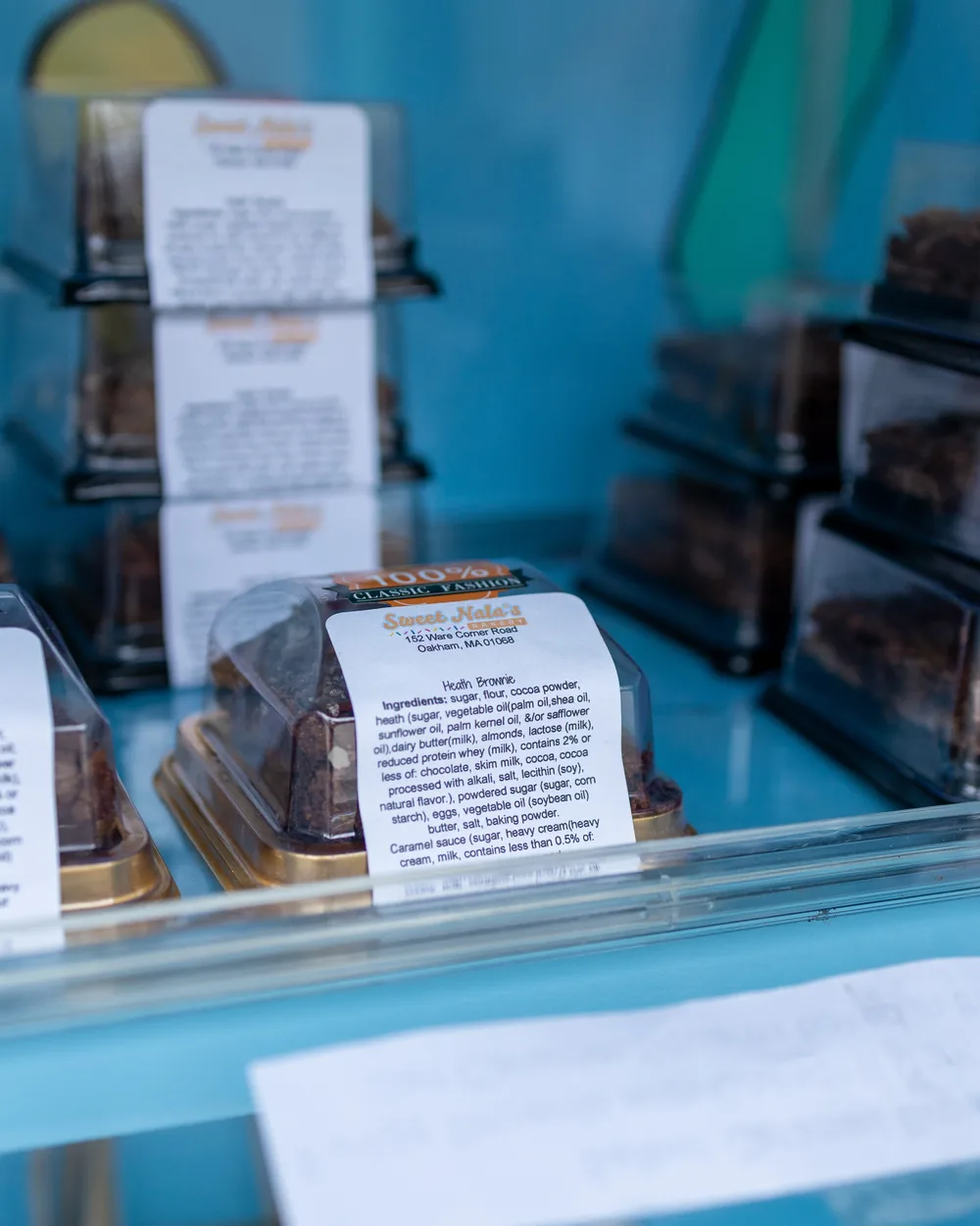Boxed treats with printed ingredient cards stacked inside the bakery cart's display case.