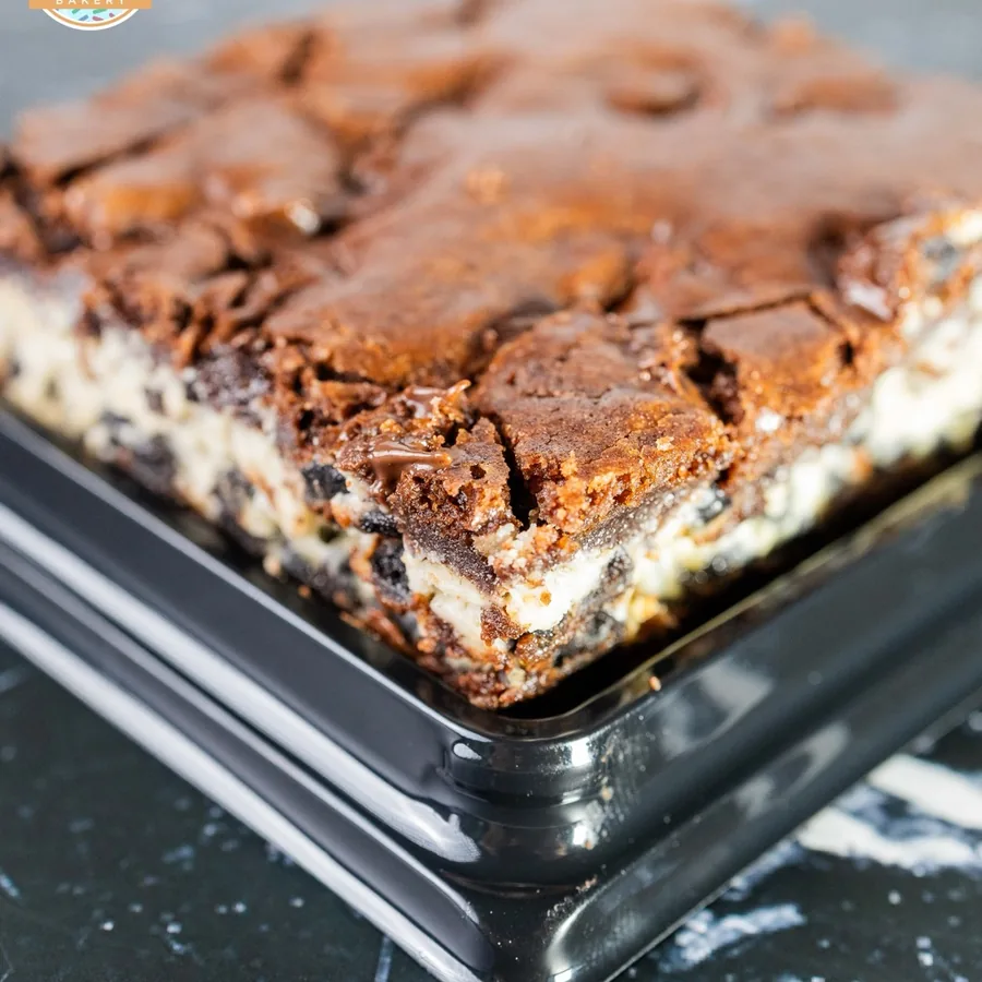 A tray of thick cookies and cream brownies with a cheesecake layer through the center.