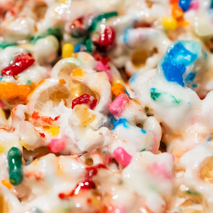 Marshmallow-coated popcorn treats covered in rainbow sprinkles.